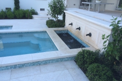 outdoor living area water feature with brass spitters